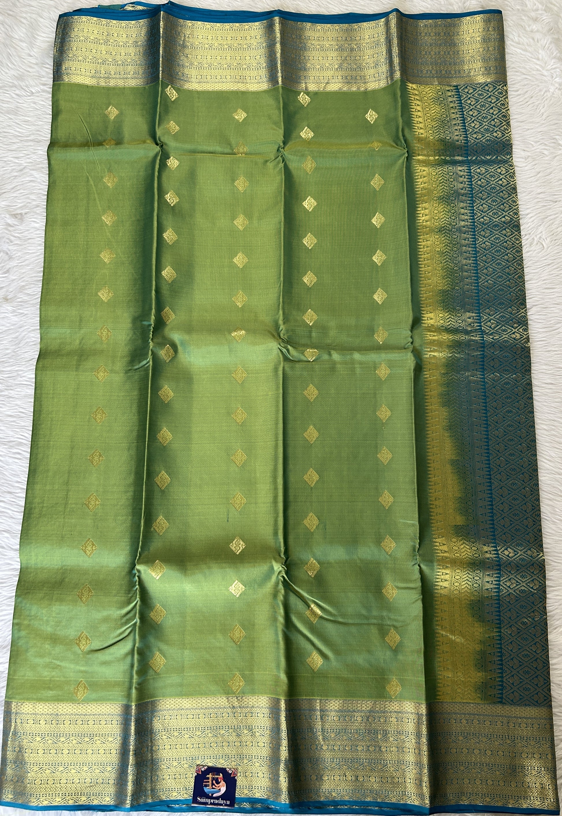 Kanjivaram Powerloom Silk Saree Green colored Saree complemented with a Blue Colored Gold Kanchi border. - Sampradaya Designer Studio