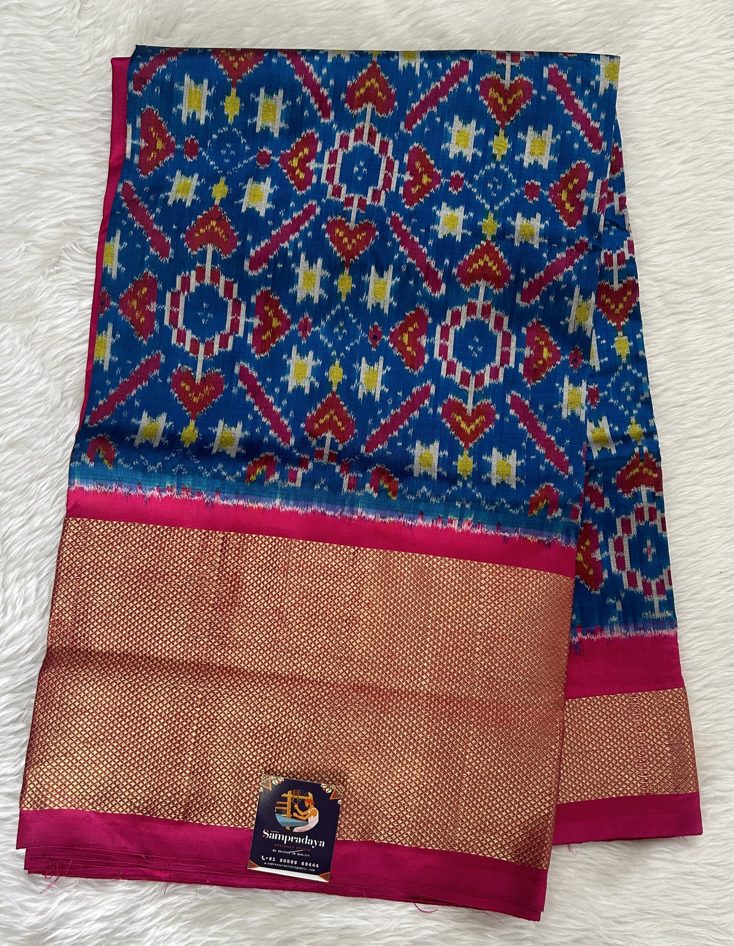 Ikkat Pattu Saree Blue colored Saree complemented with a Pink Colored Gold Kanchi border. - Sampradaya Designer Studio