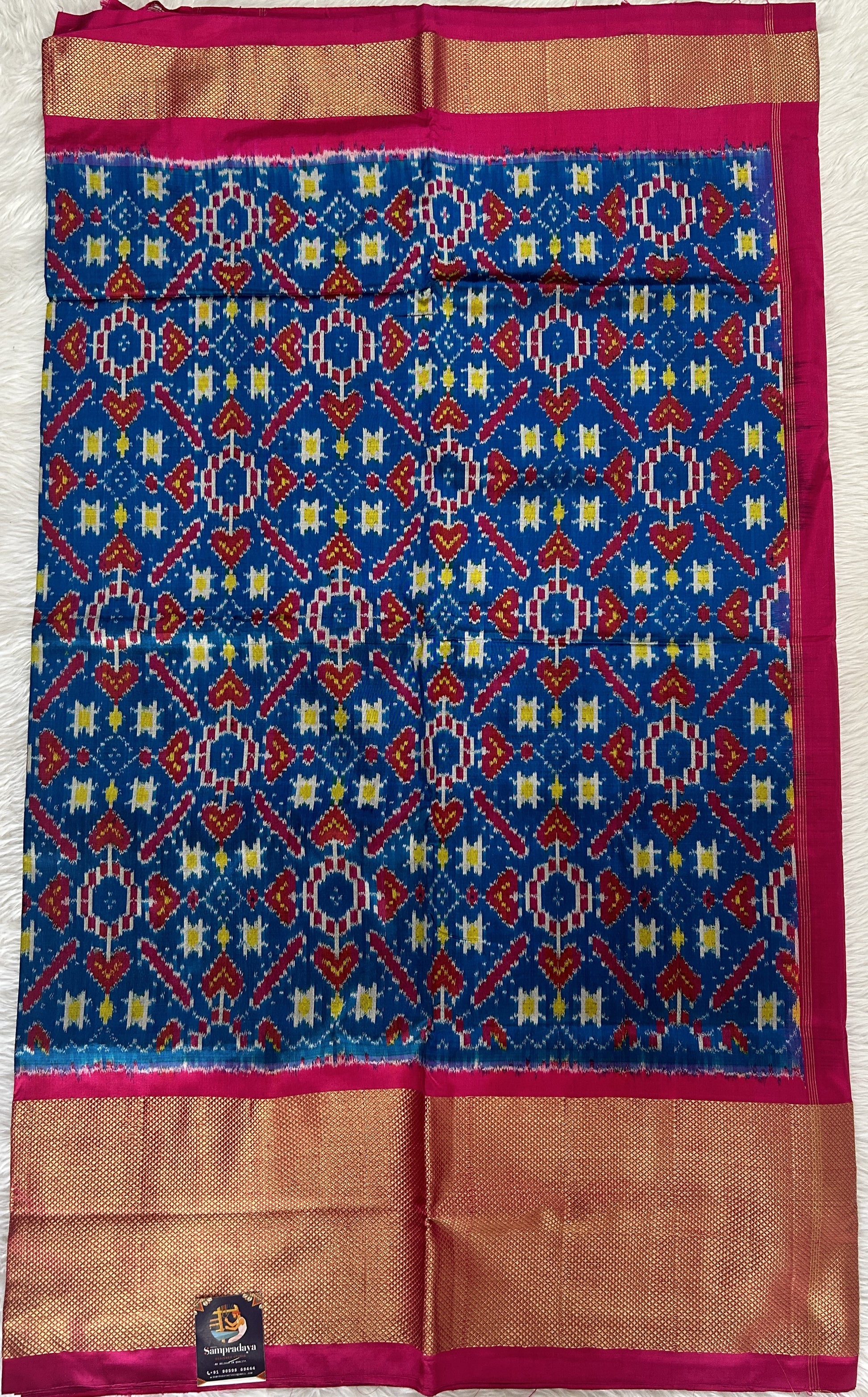 Ikkat Pattu Saree Blue colored Saree complemented with a Pink Colored Gold Kanchi border. - Sampradaya Designer Studio