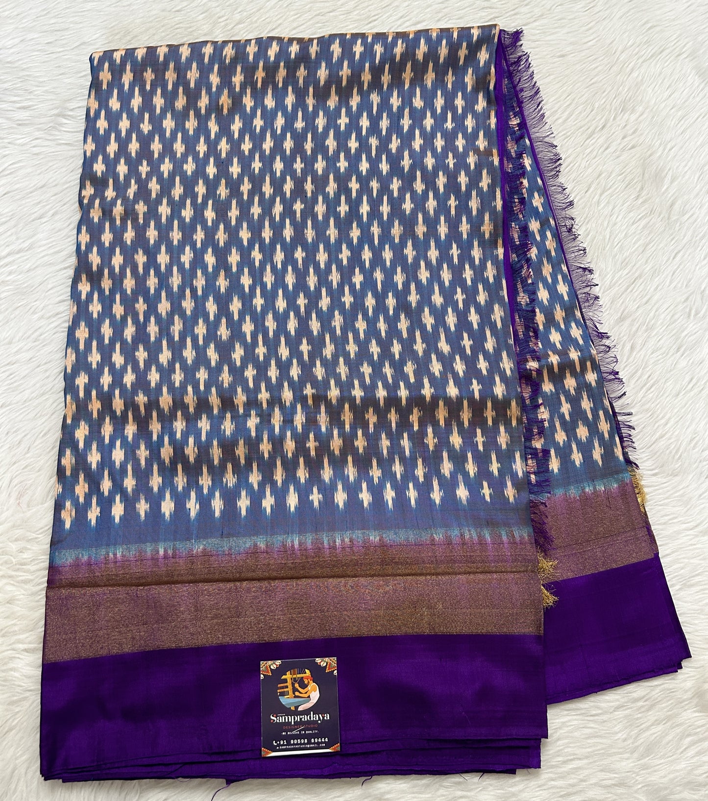 Ikkat Pattu Saree Blue colored Saree complemented with a Purple Colored Plain border. - Sampradaya Designer Studio