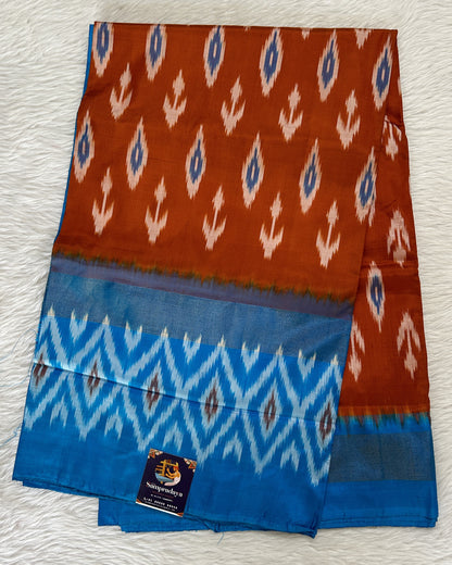 Ikkat Pattu Saree Rust Orange colored Saree complemented with a Blue Colored Ikkat border. - Sampradaya Designer Studio