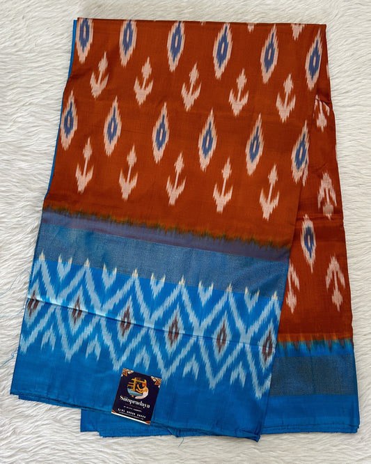 Ikkat Pattu Saree Rust Orange colored Saree complemented with a Blue Colored Ikkat border. - Sampradaya Designer Studio