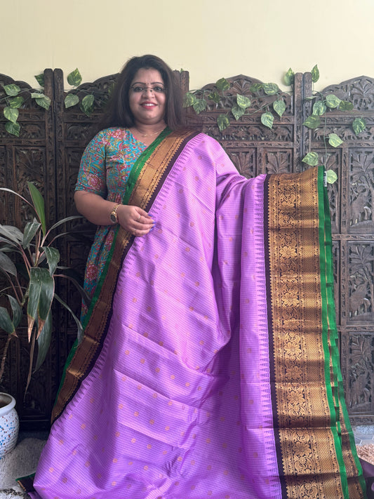 Gadwal Pattu Saree Lavender colored saree complemented with a Brown Zari border