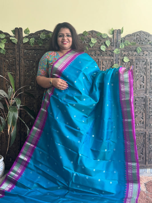 Gadwal Pattu Saree Peacock Blue colored saree complemented with a Purple Zari border