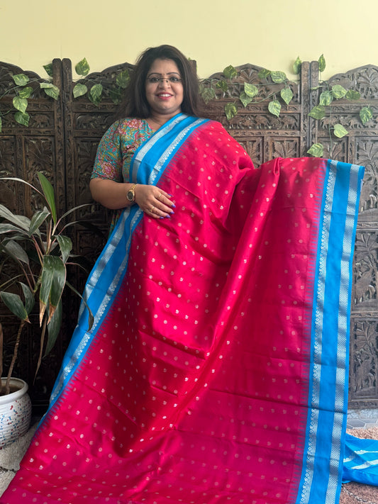 Gadwal Pattu Saree Red colored saree complemented with a Blue Zari border