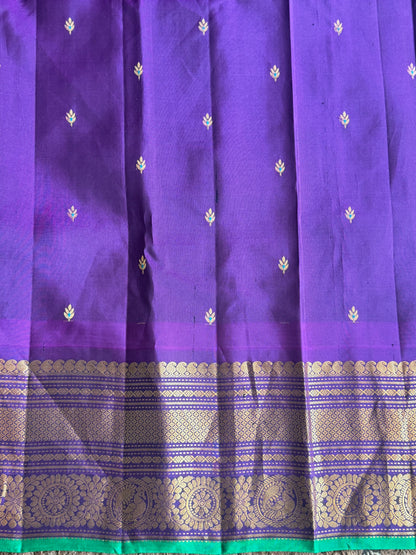 Gadwal Pattu Saree Parrot Green colored saree complemented with a Purple Zari border