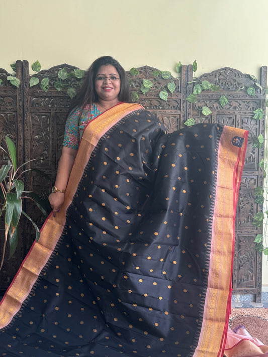 Gadwal Pattu Saree Black colored saree complemented with a Peach Zari border