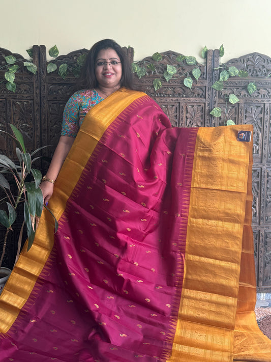 Gadwal Pattu Saree Maroon colored saree complemented with a Mustard Zari border