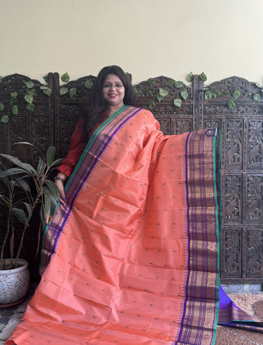 Gadwal Pattu Saree Peach colored saree complemented with a Purple Zari border