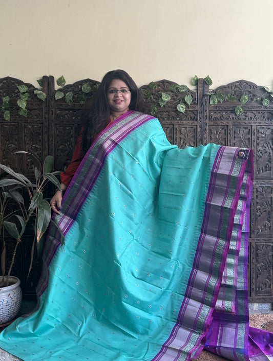 Gadwal Pattu Saree Cyan colored saree complemented with a Purple Zari border