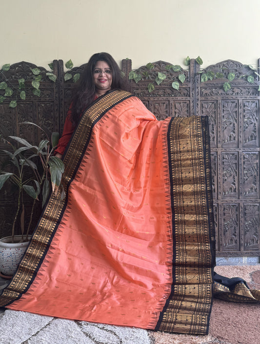 Gadwal Pattu Saree Peach colored saree complemented with a Black Zari border