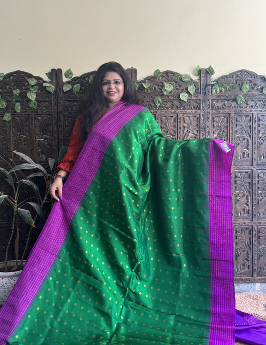 Gadwal Pattu Saree Green colored saree complemented with a Purple Checks border