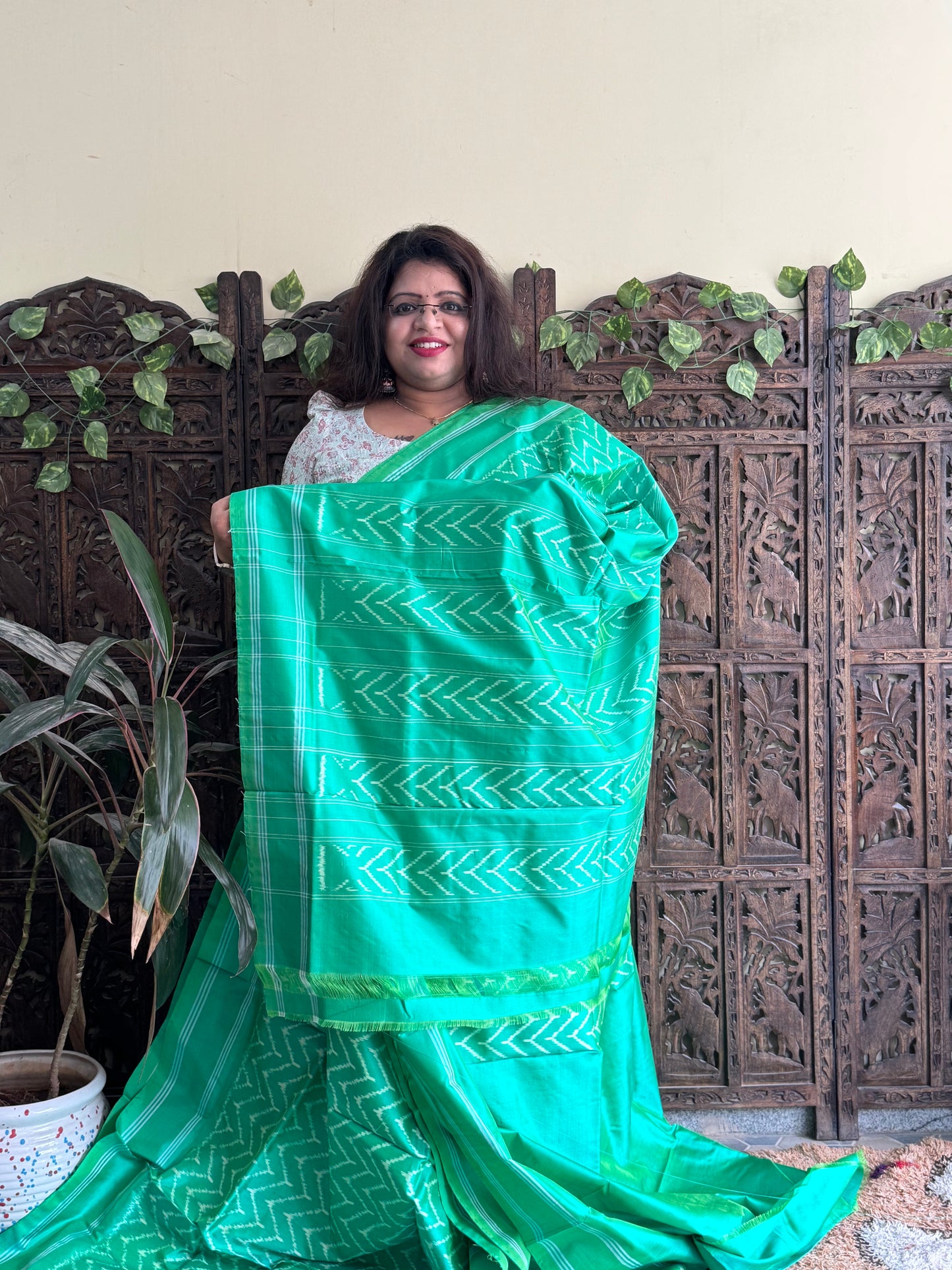 Ikkat Pattu Saree Parrot Green colored complemented with a Patola border.