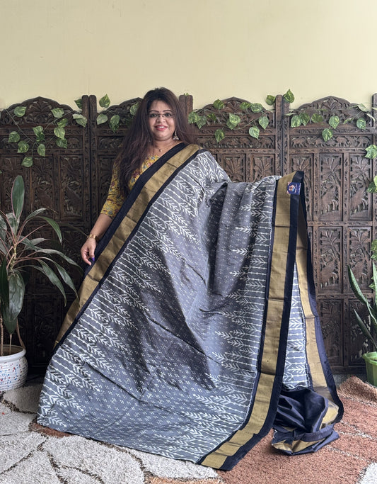 Ikkat Pattu Saree Gray colored complemented with a Black Zari border.