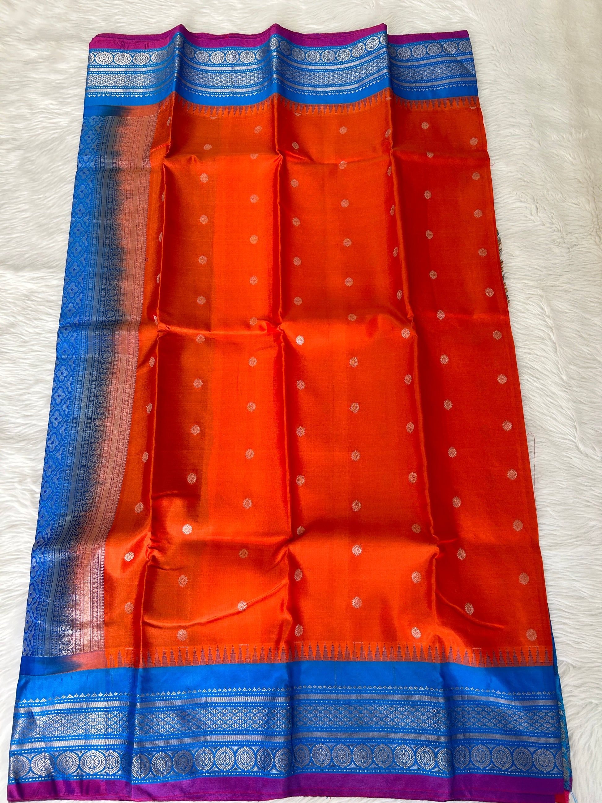 Gadwal Pattu Saree Tomato Red-colored saree complemented with a Teal Blue border - Sampradaya Designer Studio