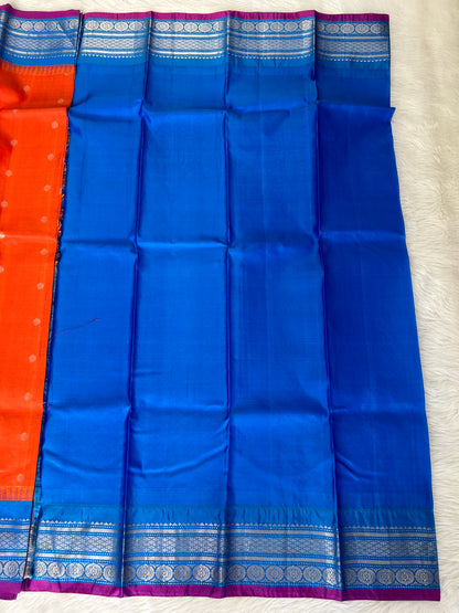 Gadwal Pattu Saree Tomato Red-colored saree complemented with a Teal Blue border - Sampradaya Designer Studio