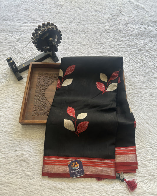 Dola Crepe Saree Black Colored Complemented with a Red Zari Border.