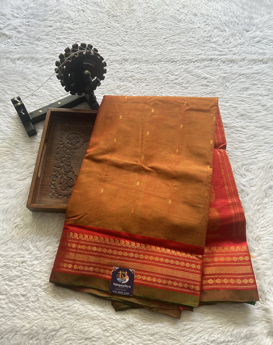 Gadwal Sico Saree Spanish Orange colored complemented with a Red Zari Border.