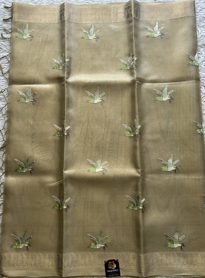 Banarasi Tissue Fancy Saree Beige Colored Paired with a Zari Border.